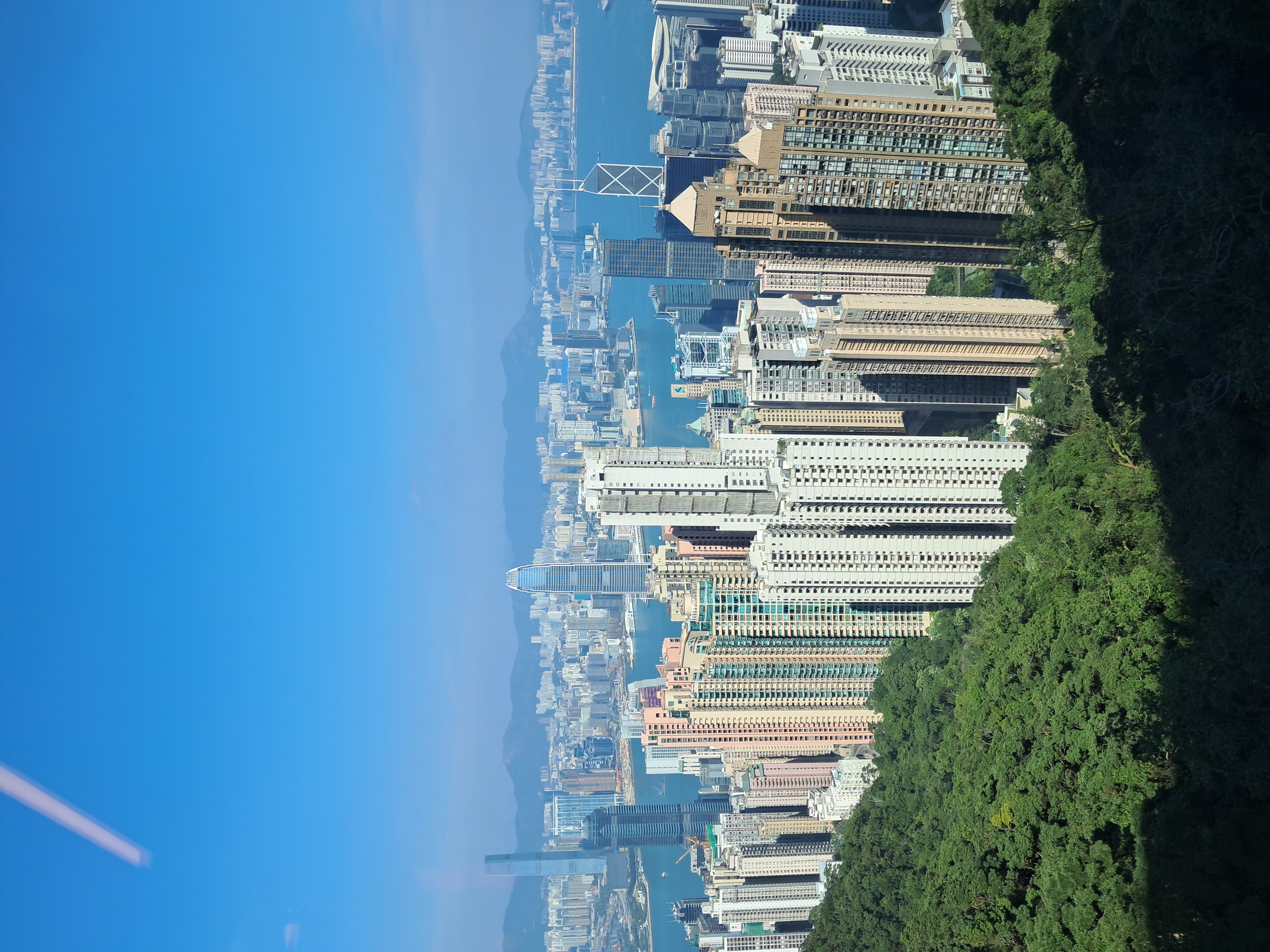 Hong Kong Island skyline overlooking Victoria Harbour at sunset.